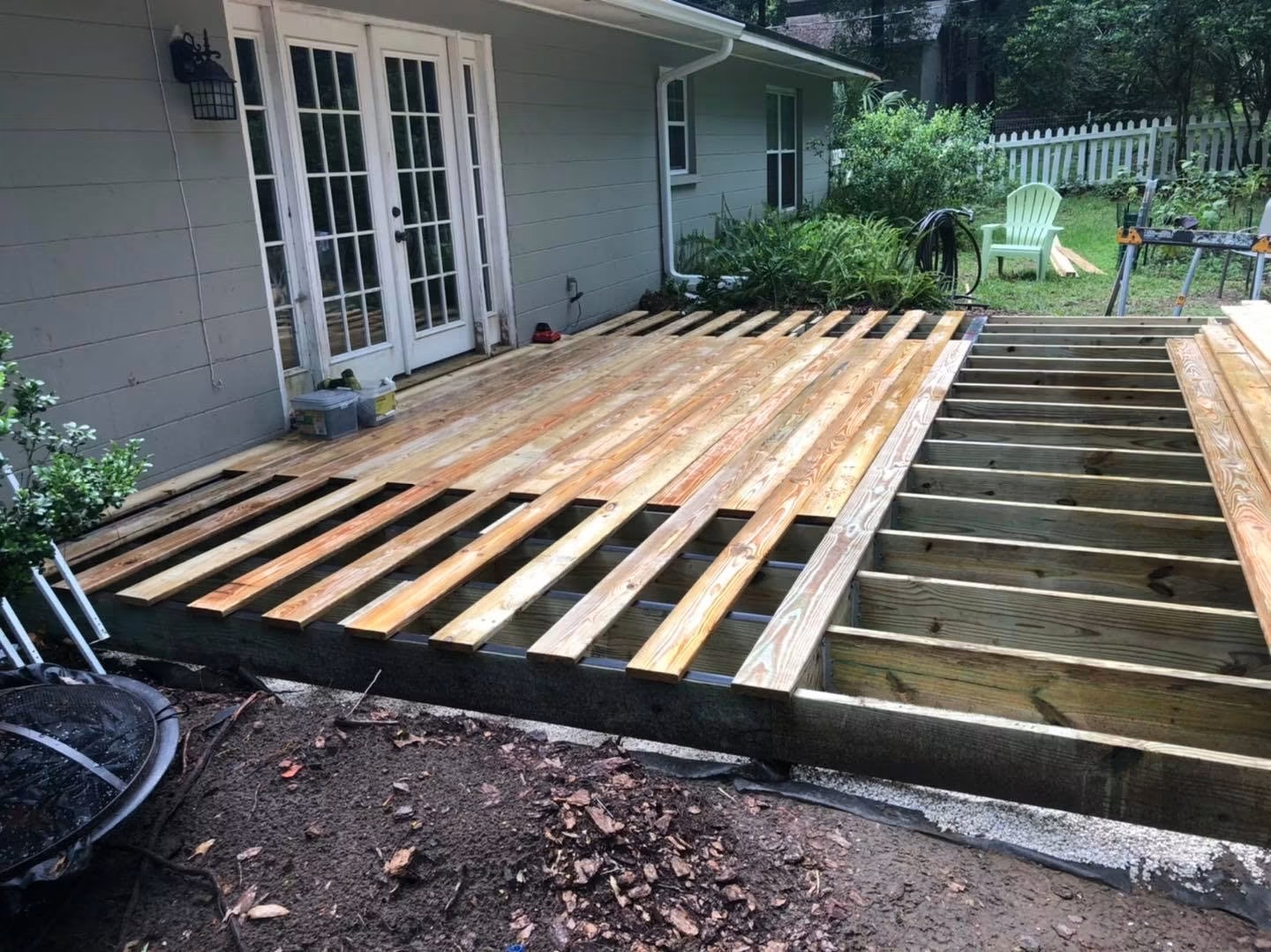 Deck build step 3 of 4: pressure-treated decking boards being laid and fastened across the finished joist frame