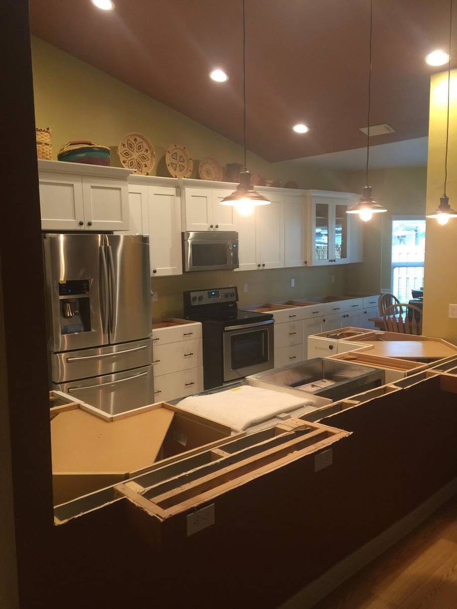 Kitchen mid-remodel with cabinet boxes open and countertops removed